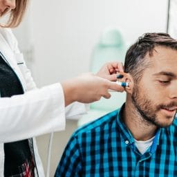 Middle age man at medical examination or checkup in otolaryngologist's office