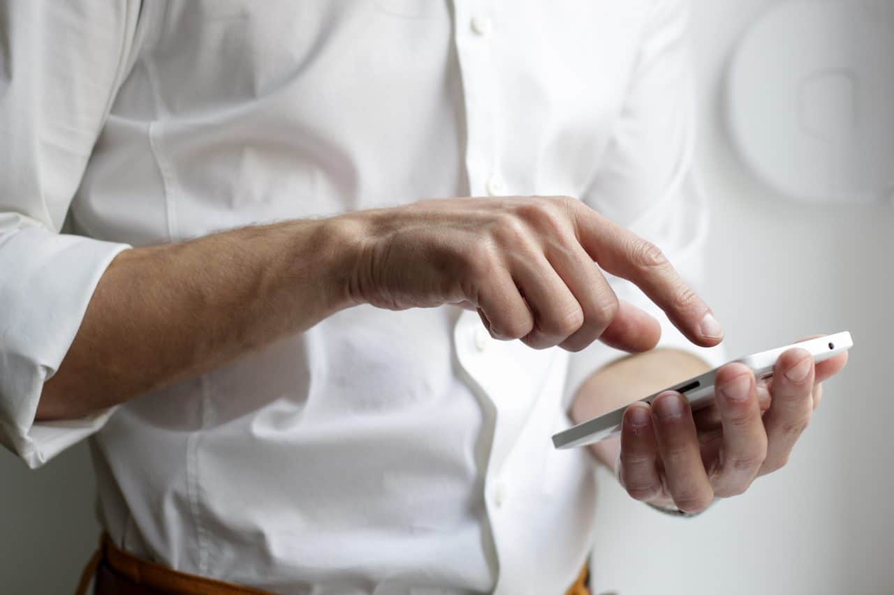 Man connecting his smartphone with his hearing aids.