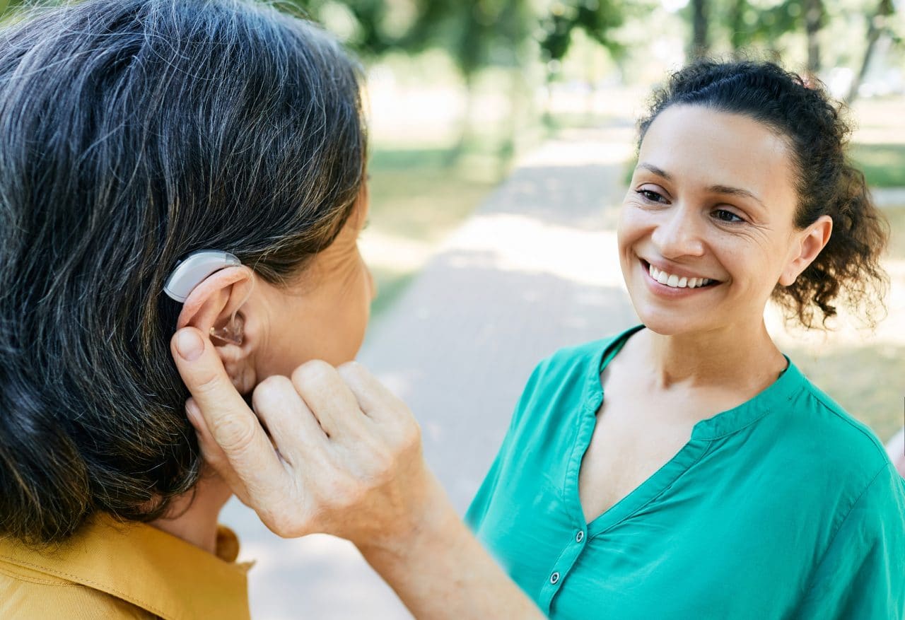 Woman with hearing aid talking with her friend.