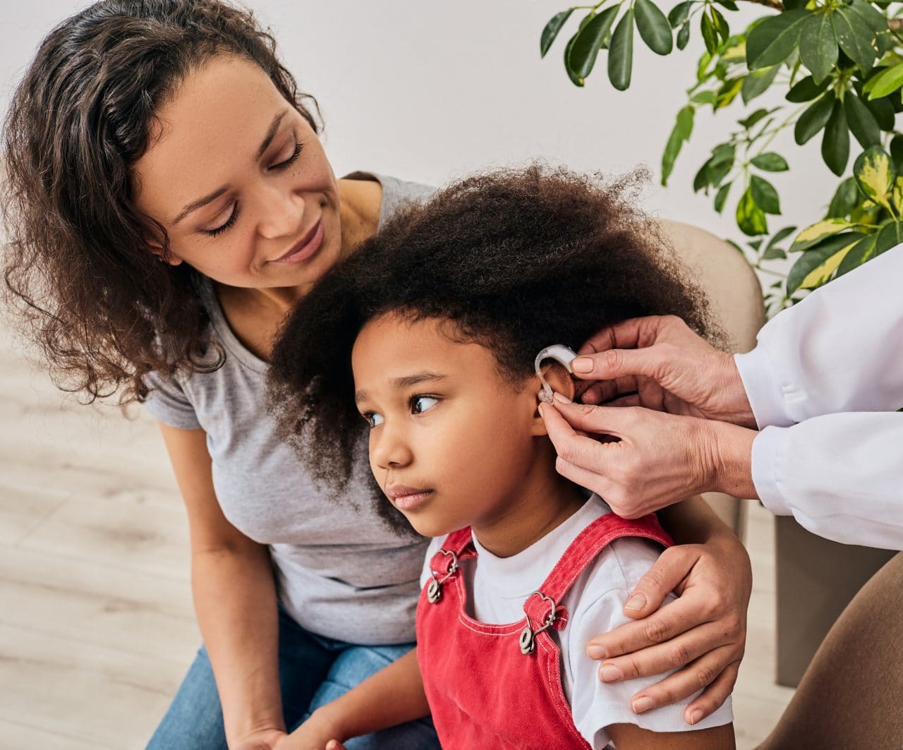 Little girl at hearing aid fitting with her mom.