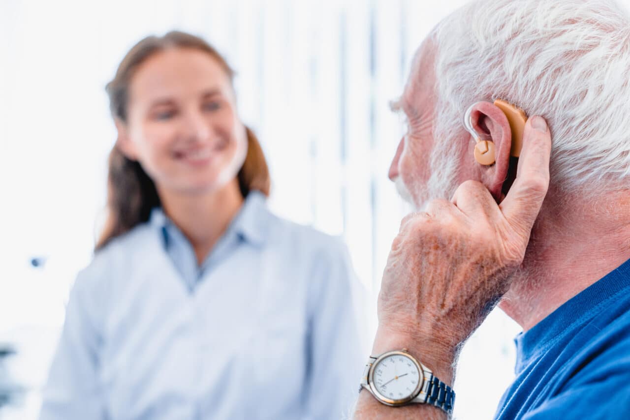 Man visiting his audiologist to talk about hearing aid issues.