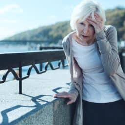Senior woman feeling dizzy outside.