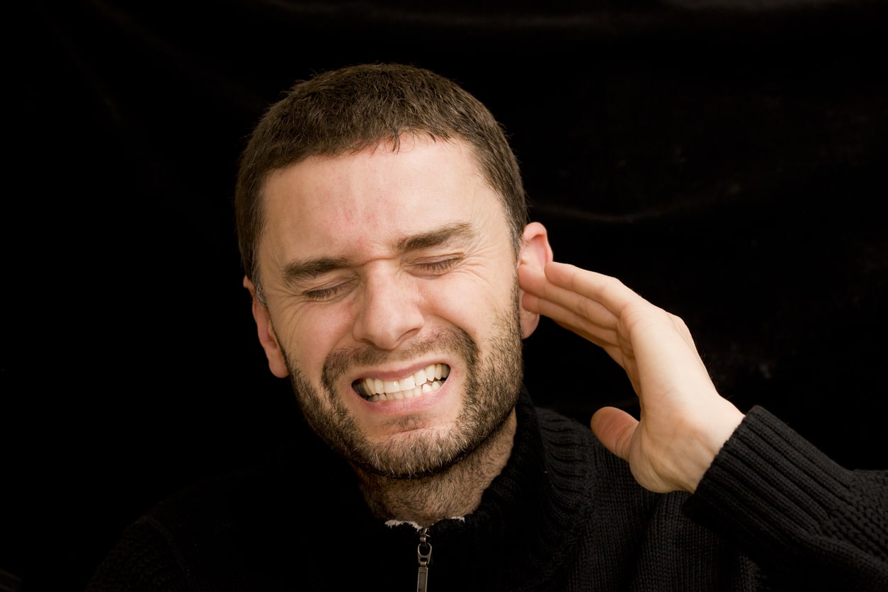 Man holds ear with earache
