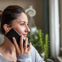 Woman with hearing aids talks on the phone