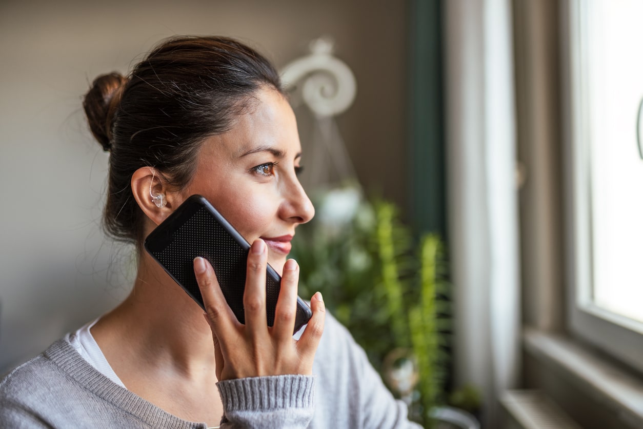 Woman with hearing aids talks on the phone