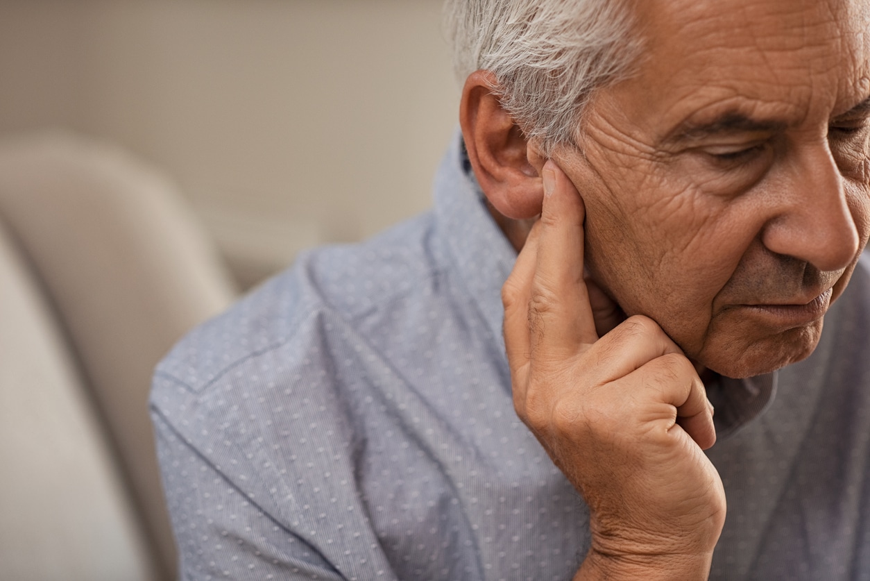 Older man holds hand to ear