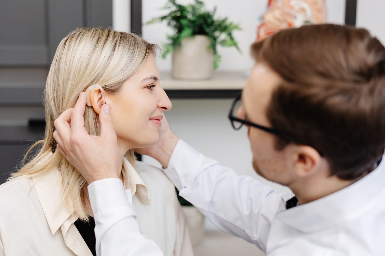 Young woman getting fit with new hearing aids.