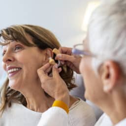 Happy woman getting a new hearing aid