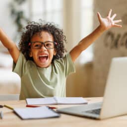 Happy young boy with his arms in the air