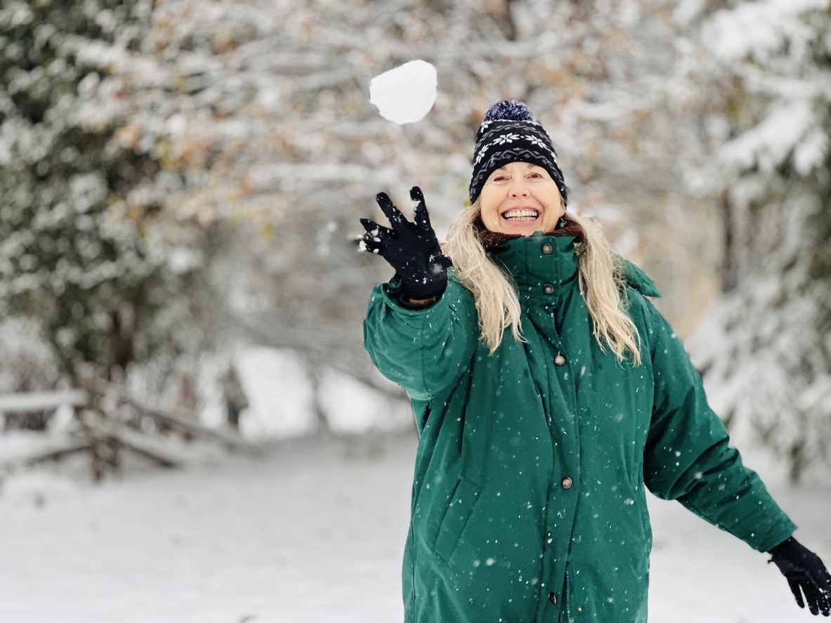 Senior woman throwing a snowball.