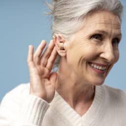 Senior woman showing off her BTE hearing aid