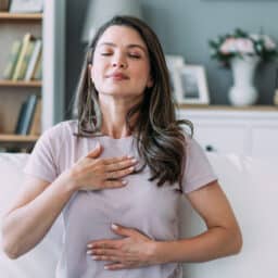Woman doing calming breathing exercises at home