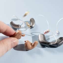Hand holding modern hearing aid