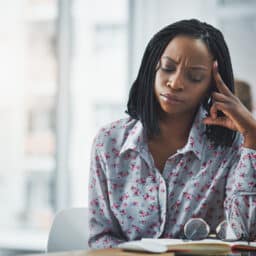 Woman sitting at her desk looking stressed