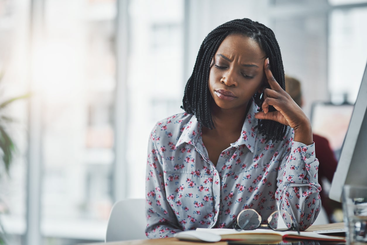 Woman sitting at her desk looking stressed
